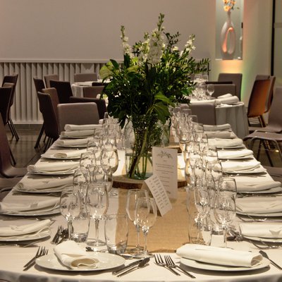 Mise en place d'une table ovale fleurie à Villa Blanche pour un mariage